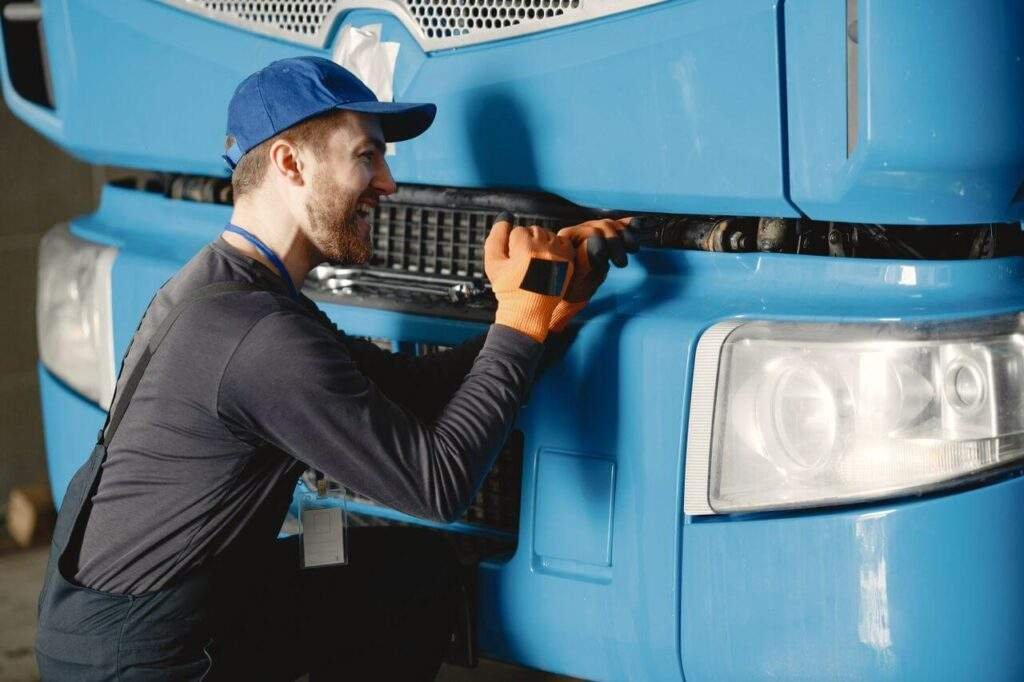 Mehaničar popravlja teretno vozilo čime omogućava bezbednost zaposlenih u transportnim firmama